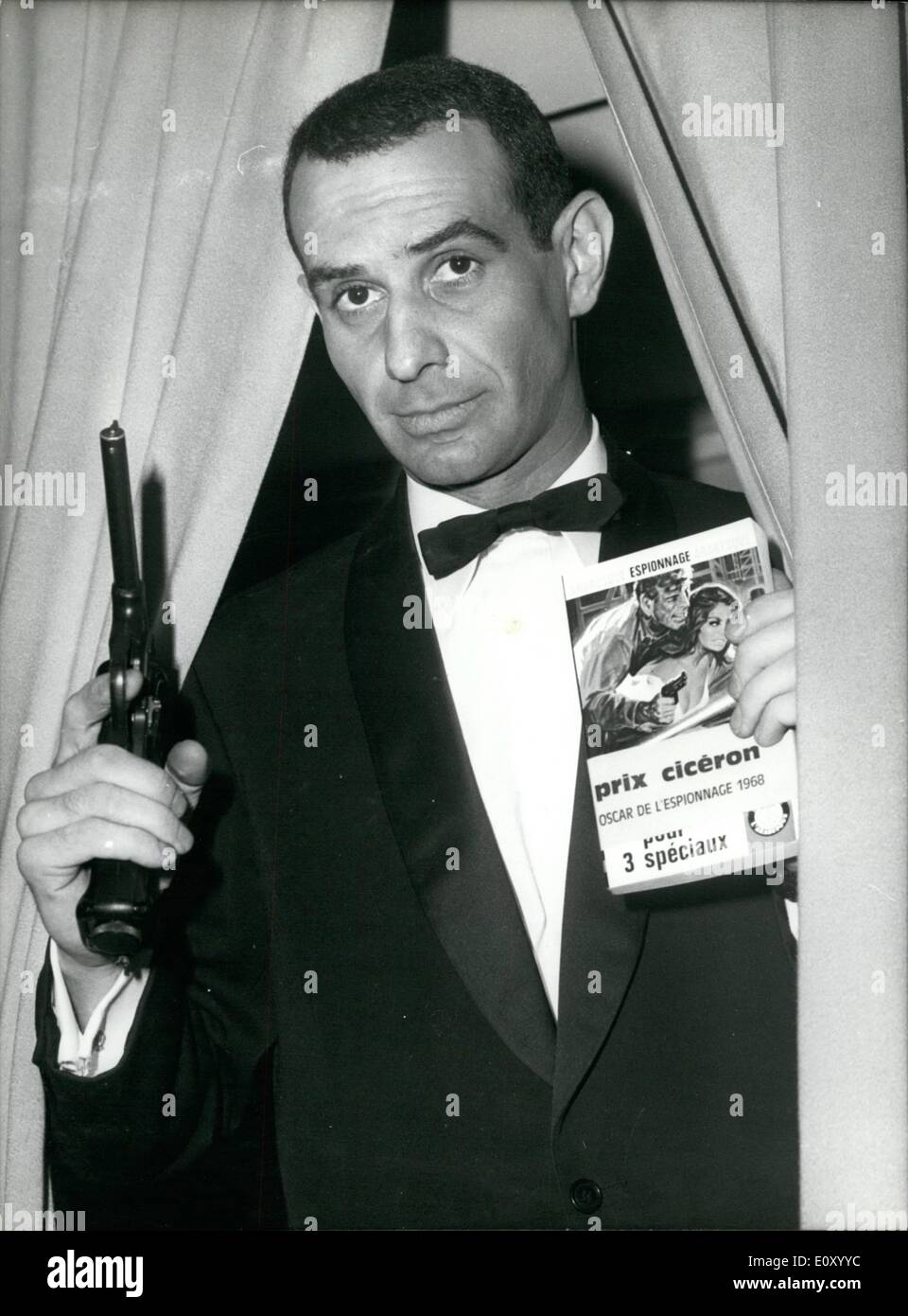 Feb. 02, 1968 - Spy Story of the year: Gerard Cambri, 40-year-old French author of Detective Novels, was awarded the 'Cicero' Oscar for the best spy story of the year. Photo shows holding a pistol in one hand to give himself a 'Spy' toucn and his book 'Sarabande Pour Trois Speciaux' in the other Gerard Cambri poses for the press. Stock Photo