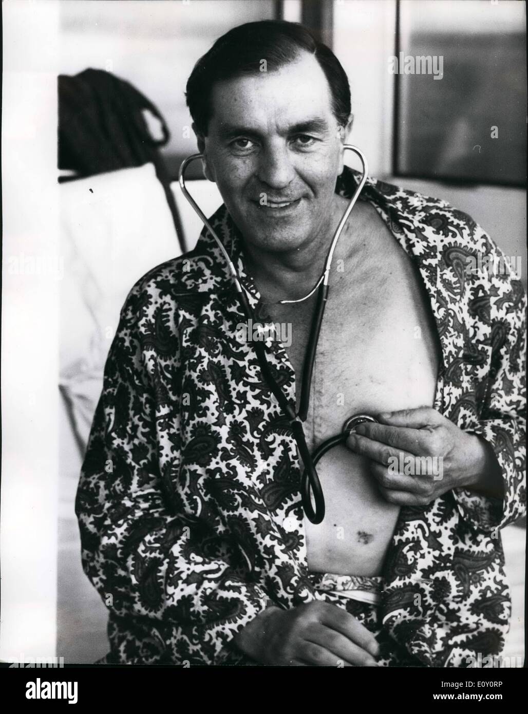 May 05, 1968 - Listening to his new heart.: Mr. Fred West, 45, of Leigh-on-sea, British's first heart transplant patient, showing his stitched-up chest, listens to the beat of his new heart at the National Heart Hospital, Marylebone, London, today. Yesterday, Mr. West was moved from the theatre where the operation took place three weeks and three days ago, into his own hospital suite. Mr. West received the heart of Irish-born carpenter. Mr. Patrick Ryan,26, who died following a fall from a building site. Stock Photo