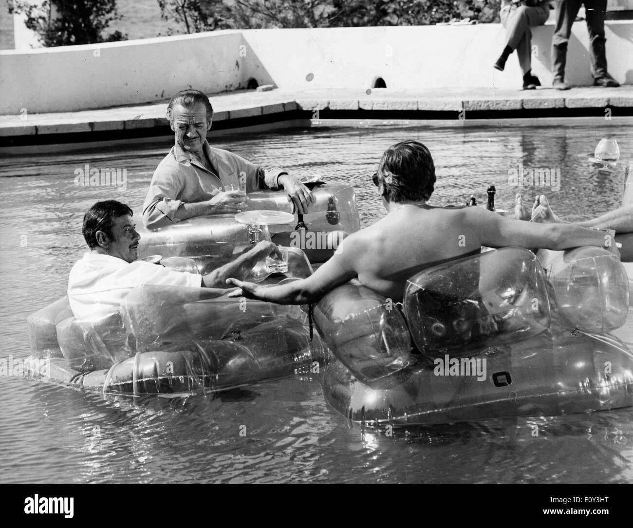 Actors David Niven and Eli Wallach conference in the pool Stock Photo