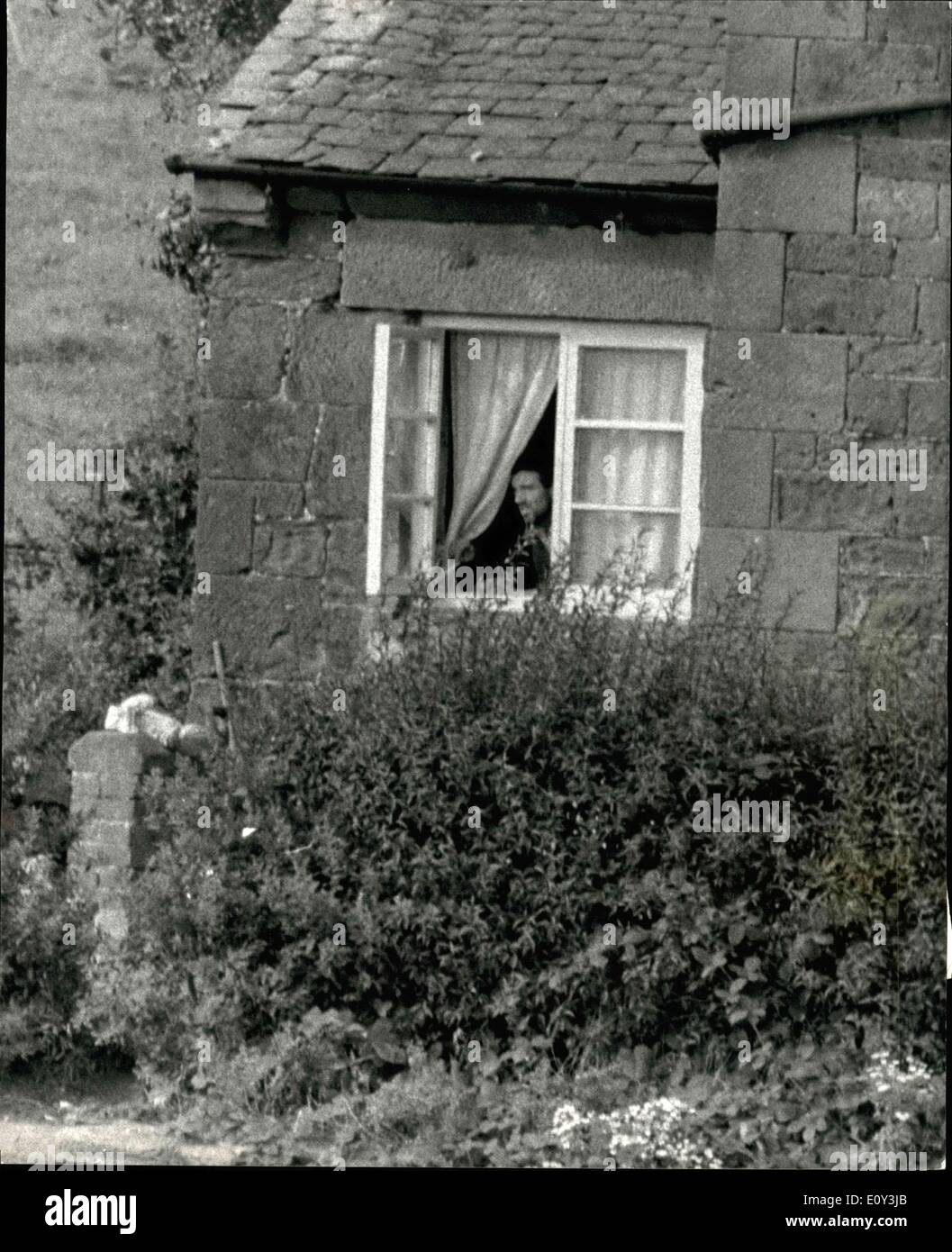 Sep. 24, 1968 - Gunman emerges from besieged cottage to collect food.: John James, the Shropshire gunman besieged in his cottage at Weston-under-Red castle emerged fir the first time yesterday to collect groceries from. He carried his shotguns under his arms. James walked six paces to an outhouse wall and collected loaf of bread, a tin of luncheon meat, butter and water left by Mr. To Hedlington, his brother in law. He turned and went inside. it is now six days since James barricade himself in the cottage with his wife, Joyce and four young children Stock Photo
