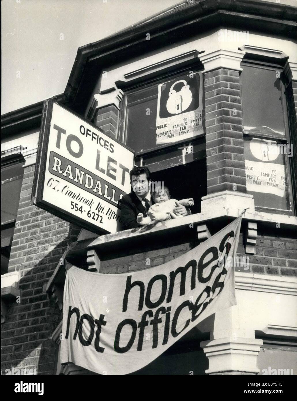 Feb. 09, 1969 - February 9th, 1969 London squatters campaign installs homeless families in empty property. The London Squatters Campaign today installed a number of homeless families in empty property in Ilford, who barricaded themselves in . Keystone Photo Shows: Mr. Daniel McNally, one of the squatters seen at the window of an empty house in Oakfield Road, Ilford, with his ten month old baby Tracey. The house was to let as offices and not as a house. Stock Photo