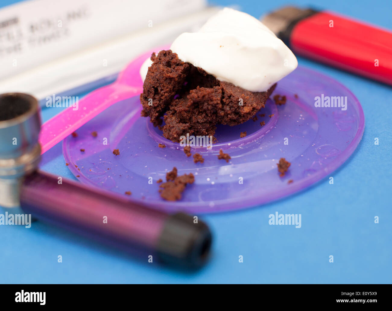 Hash Brownie or Space Cake topped with creme fraiche framed by smoking paraphernalia, London Stock Photo