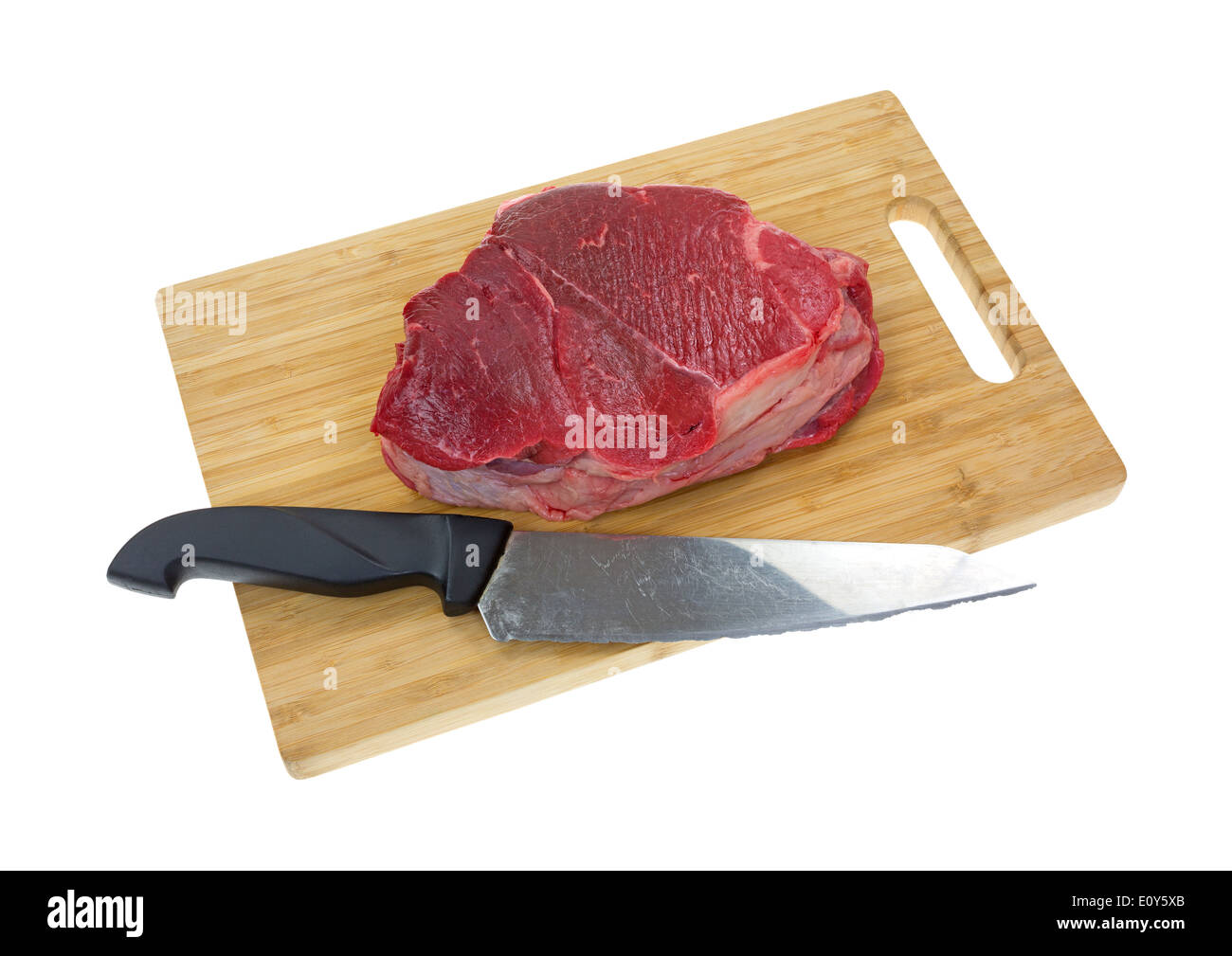 A large chuck roast on a wood cutting board with a knife on a white background. Stock Photo