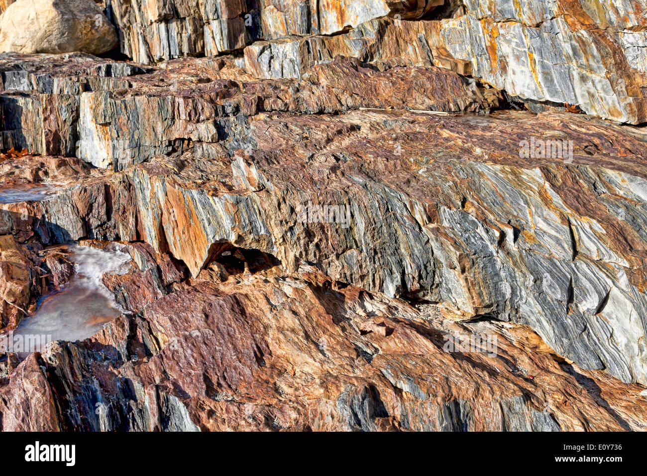 Tiered colorful rocks with pockets of frozen water. Stock Photo