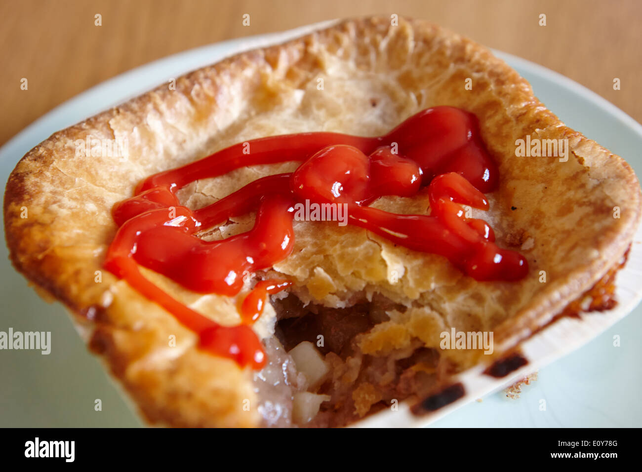 baked scouse pie in carton covered in tomato sauce Stock Photo