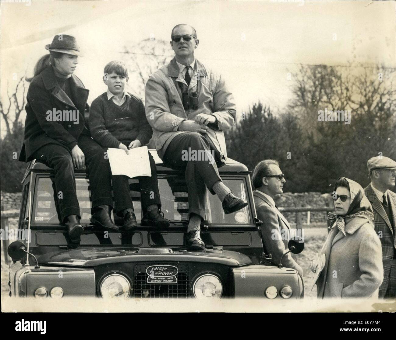 Apr. 04, 1969 - Royal Spectators at the Badminton Horse Trails on the Duke of Beaufort's Estate: The Queen with Prince Philip and other members of the Royal Family today attend the Badminton Horse Trials, held at Badminton, Gloucestershire, the home of the Duke of Beaufort. Photo shows the Queen wearing a headscarf stands beside a Landrover while Princes Anne, Prince Andrew and Prince Philip sit on the roof of the vehicle watching today's events. Stock Photo
