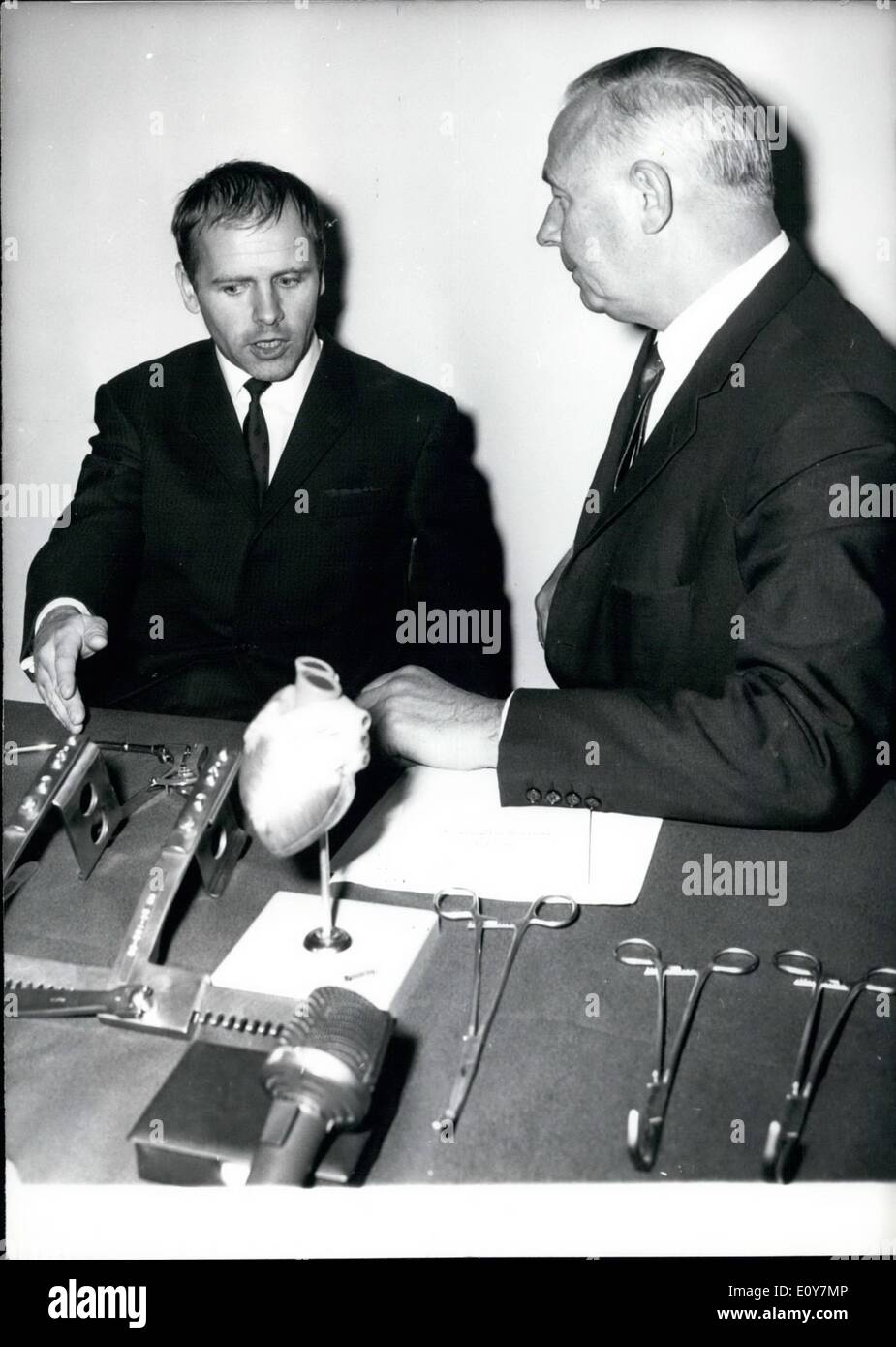 Apr. 04, 1969 - Pictured from left to right: Dr. B.J. Messmer of Houston, Texas(Colleague of Professor D.A. Cooley). Professor Dr. Vossschulte. Dr. Messmer is informing Professor Dr. Vossschulte about medical devices such as a plastic heart, which was used in a heart tra Stock Photo