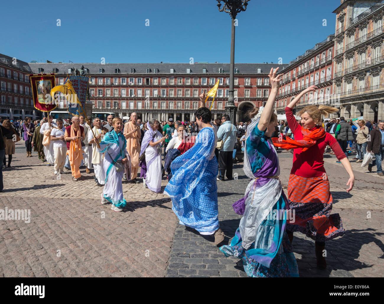 A group of Hare Krishna devotees pass through the Plaza Mayor in the centre of Madrid, Spain Stock Photo