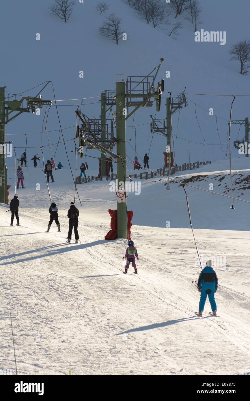 Skiers on a ski lift at Le Mont Dore ski resort, Massif du Sancy, Auvergne, France Stock Photo