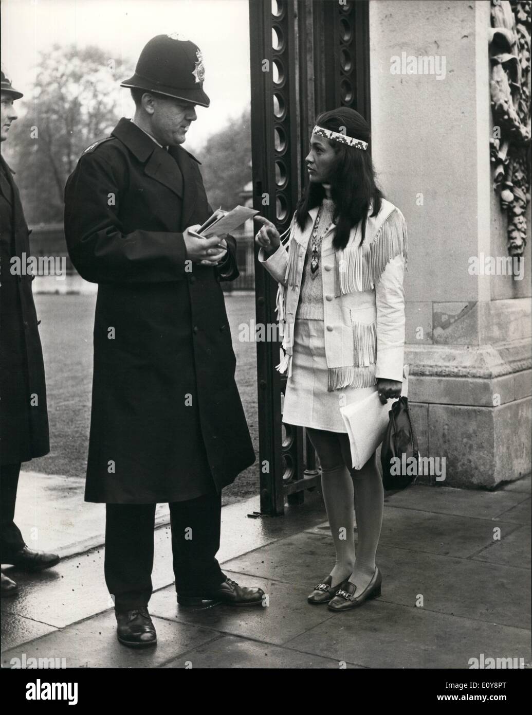 May 05, 1969 - Red Indian Mohawk girl at no. 10. Miss Kahn Tineta Horn, 27, a Red Indian Mohawk girl, of caughnawage Ircqucis Land, Quebec, who wants to ask Mr.Wilson to persuade the Canadian government to allow Indians to cross the united states Canadian border without paying customs duties - this morning went along to no 10 downing street. Photo shows Miss Kahn Tineta Horn talks to a policeman at the gates of Buckingham palace to whom she gave notes in her effort to gain an appointment with the Queen. Stock Photo