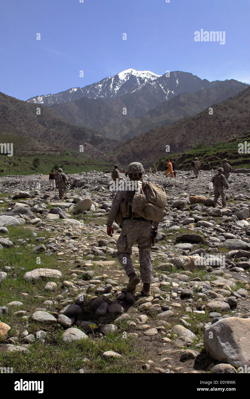US Army soldiers patrol along a riverbed during a mission in the mountains April 19, 2009 in Kunar province, Afghanistan. Stock Photo