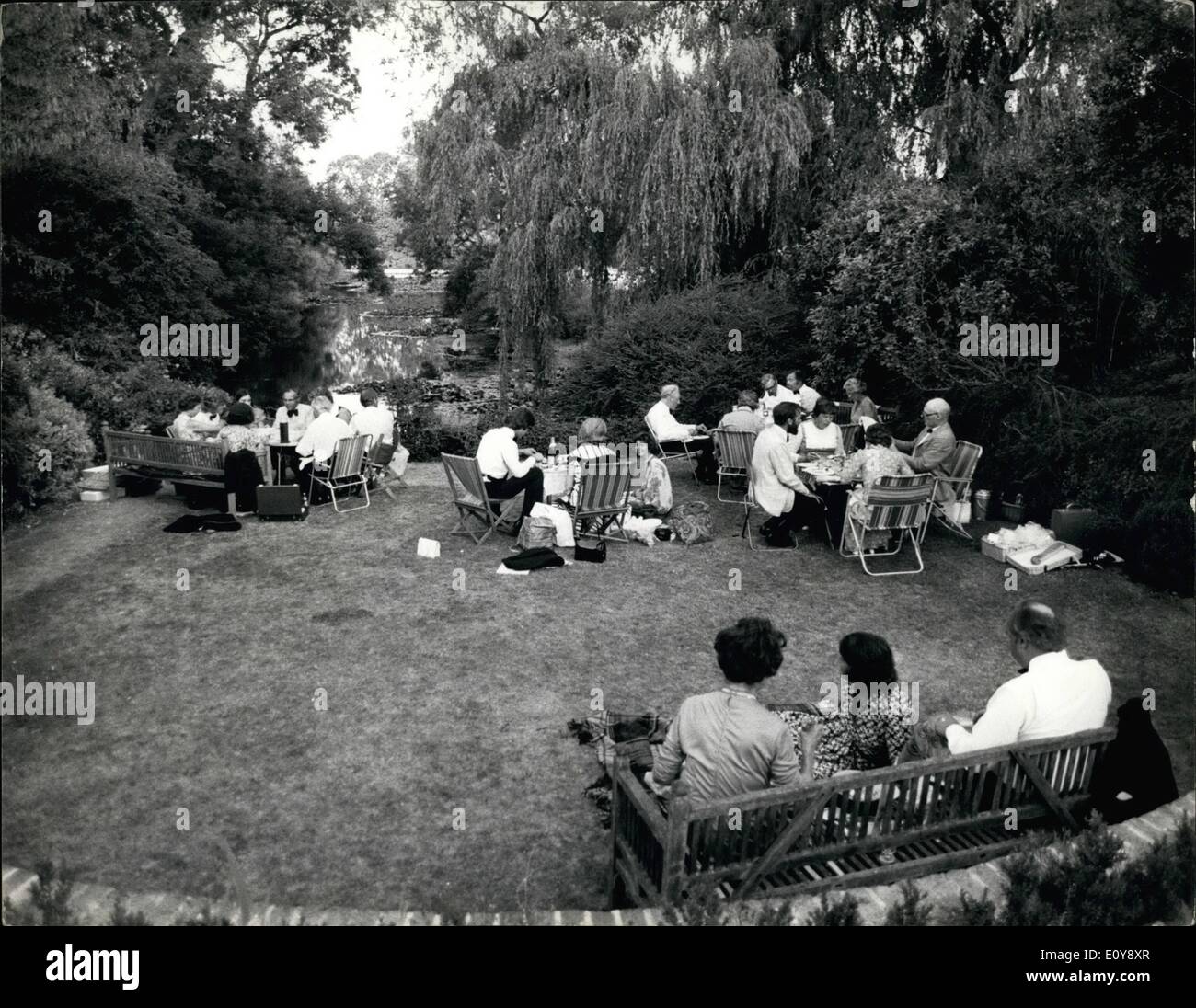 Feb. 02, 1969 - Despite the scorching temperatures, presently sweeping through Britain, traditional behavior at Glyndebourne, the home of music lovers, has not altered very much. As is the usual practice, during the dinner interval the fraternity that frequent this musical paradise, take to the spacious lawns and fields to enjoy a traditional champagne dinner, with the men clad in full evening dress and ladies likewise. Our photographer visited Glyndebourne this week, to see how the guests were coping with the heatwave Stock Photo