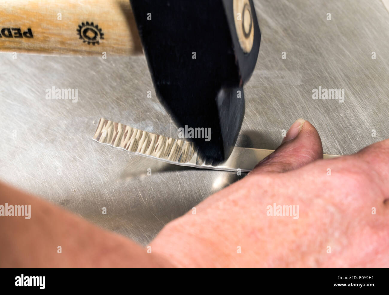 Artisans Nicole & Harry Hansen, Sterling & Steel, create original sterling silver and iron pieces. Close-up of hand and tool Stock Photo