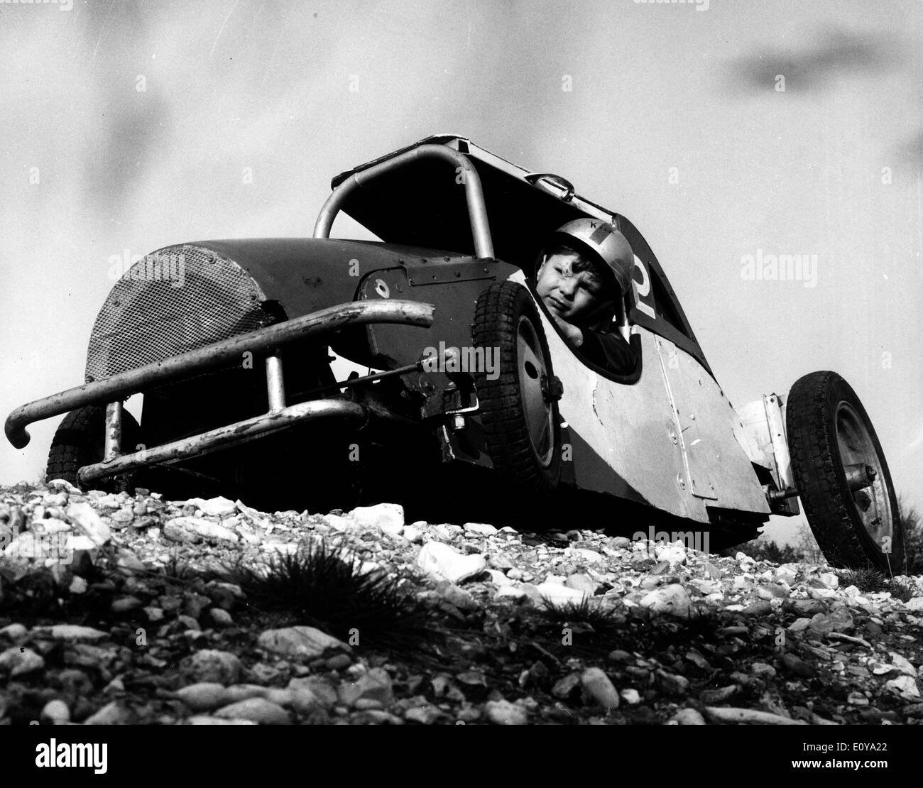 Jun 18, 1969; Surrey, UK; The dare devil, KEIR DOE, who is only five years old, skillfully guides his stock car over rough Stock Photo
