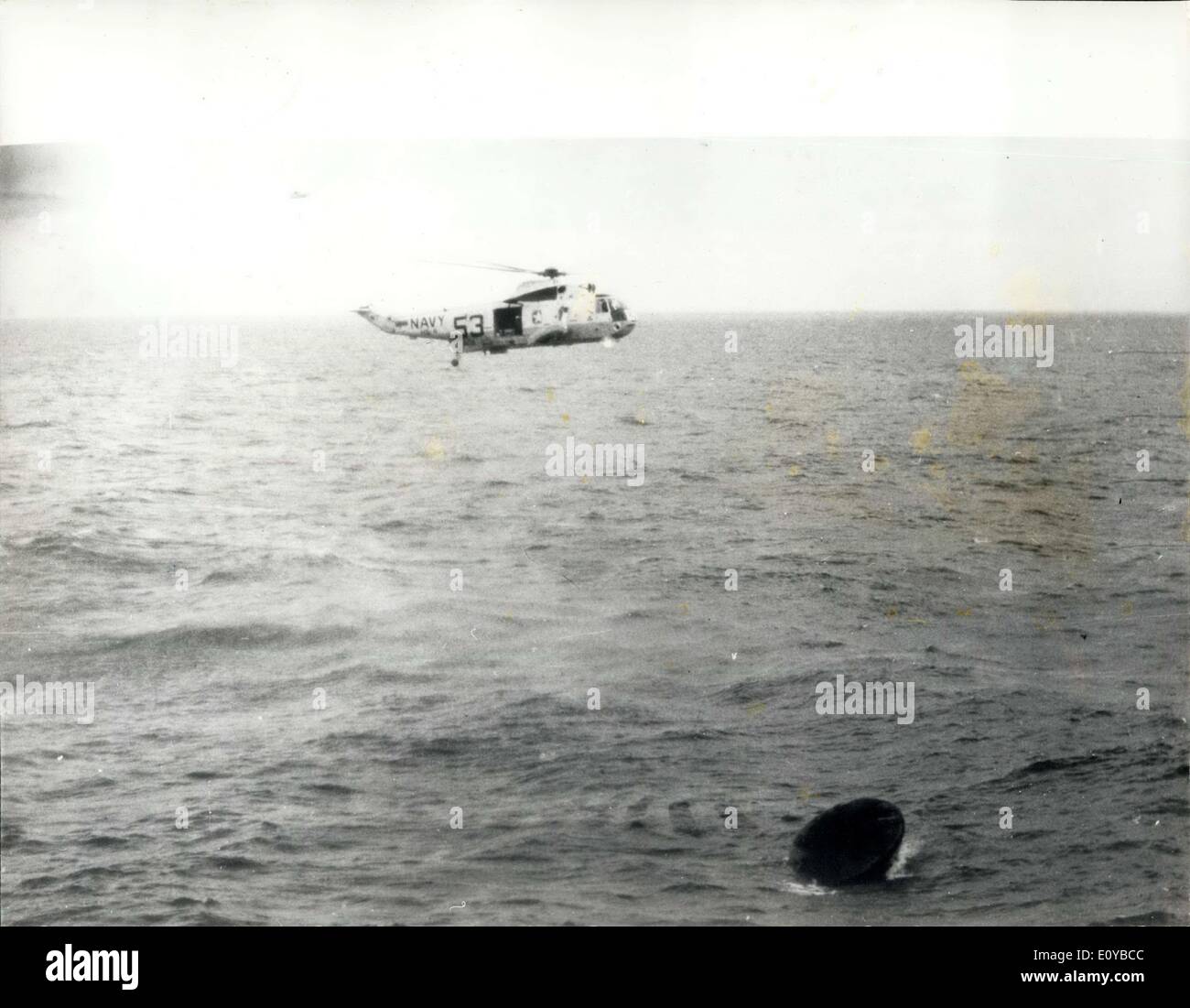 Jul. 29, 1969 - Apollo 11 Splashdown: A rescue helicopter never above the 11 spacecraft seconds after it splashed down in the pacific ocean at 12.5 P.M. EDT July 24, 1969. The spacecraft turned apex down after impact, as shown here, but inflatable begs repositioned the spacecraft shortly after this view was taken. Splashdown and recovery took place 900 miles southwest of Hawaii, eight days after astronauts Neil Armstrong, Michael Collins and Edwin Aldrin, performed man's first lunar exploitation mission. Stock Photo