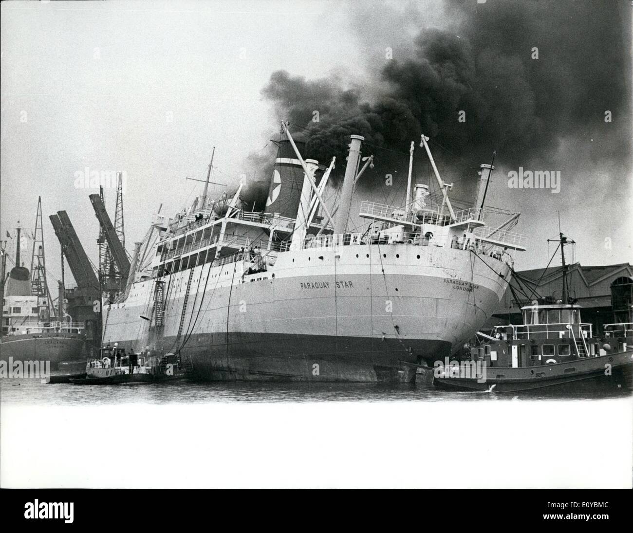 Aug. 08, 1969 - Firemen Fight Ship Blaze: 100 iremen fought for 12 hours to bring under control a fire which broke out at dawn yesterday in the engine room of the British Blue Star Line cargo ship Paraguay Star, 10,722 tons, in London's Royal Victoria Docks. The ship developed a list and the heat was so intense that it blistered the hull's paintwork, Photo shows Smoke pours from the Paraguay Star in London Royal Victoria Docks yesterday. Stock Photo