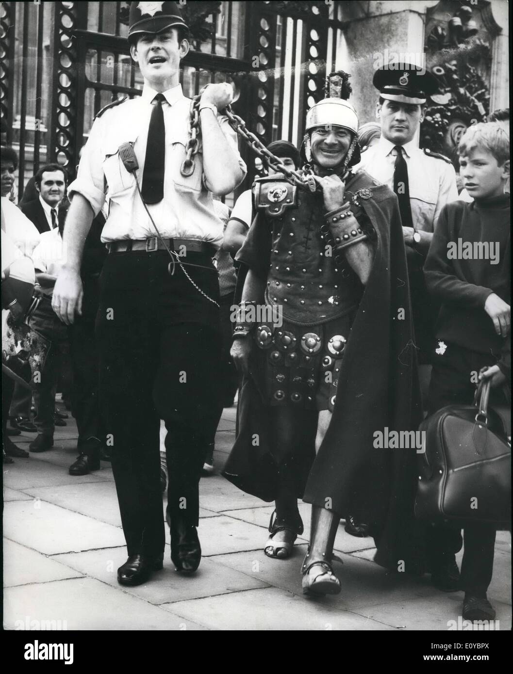 Aug. 08, 1969 - ''Centurion'' Chains Himself To Palace Gates. ''Centurion'' Walter Yearrick, 45, a former Top Sergeant in the United States Air Force, being led away after he had chained himself to the gates of Buckingham Palace in protest against the lack of money being spent on investigating Roman remains. He is to appear at Bow Street charged with obstruction and using insulting behaviour. Stock Photo