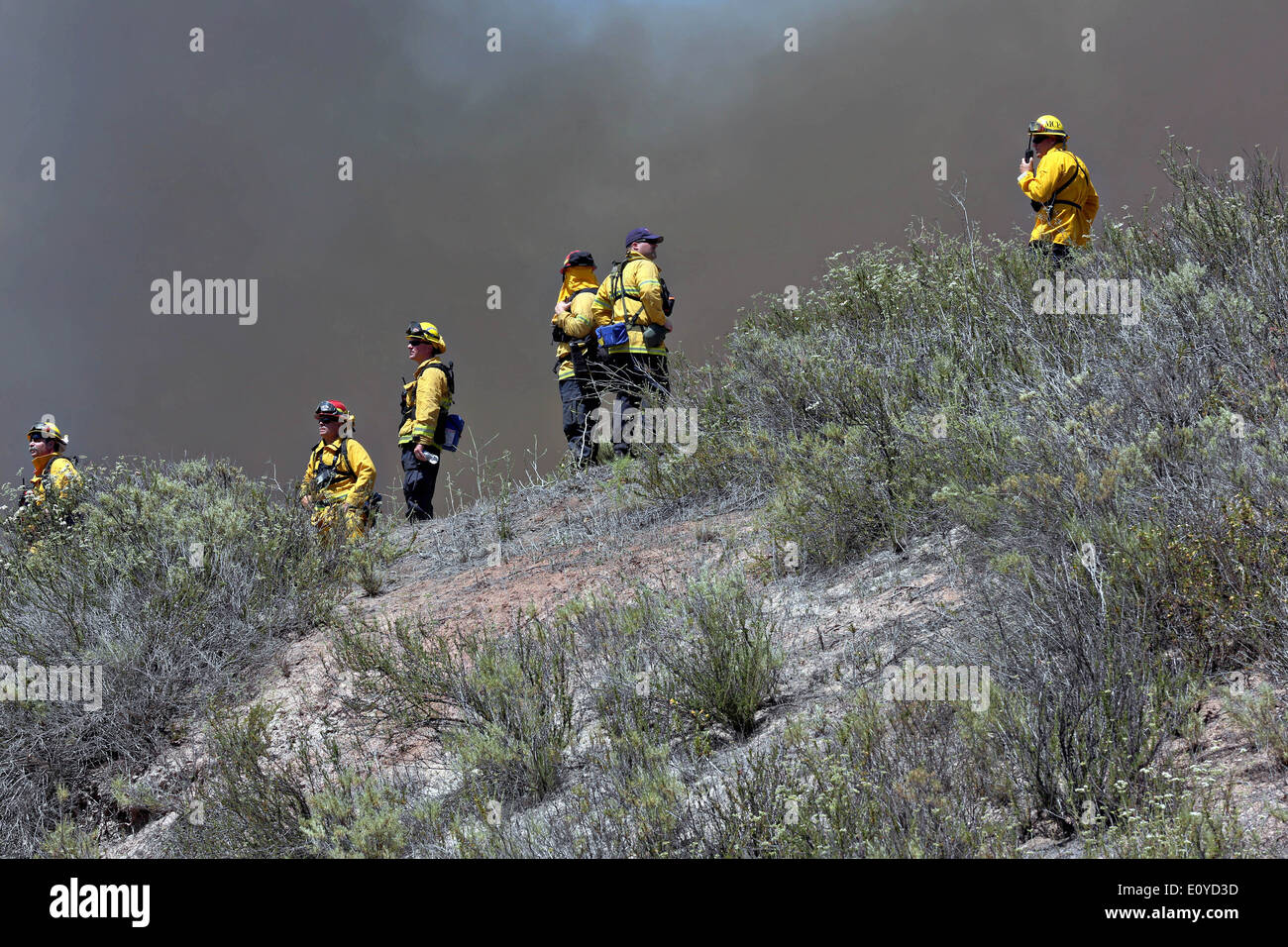 Calfire firefighters monitor water drops on the Tomahawk and Las Pulgas wildfires as they burn the foothills May 16, 2014 around Camp Pendleton, California. The Las Pulgas Wildfire in Camp Pendleton has burned more than 15,000 acres and is the largest fire in San Diego County history. Stock Photo