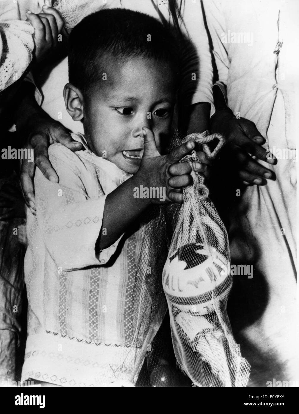 Jan. 01, 1970 - Phan Rang, Vietnam - A Vietnamese child inspects toys given by the 1st Brigade of the 101st Airborne Division to 400 children whose fathers serve in the Vietnamese forces. In the 1950's, the US began to send troops to Vietnam, during the following 25-year period, the ensuing war would create some of the strongest tensions in US history. Almost 3 million US men and women were sent to fight for what was a questionable cause. In total, it is estimated that over 2,5 million people on both sides were killed. Stock Photo