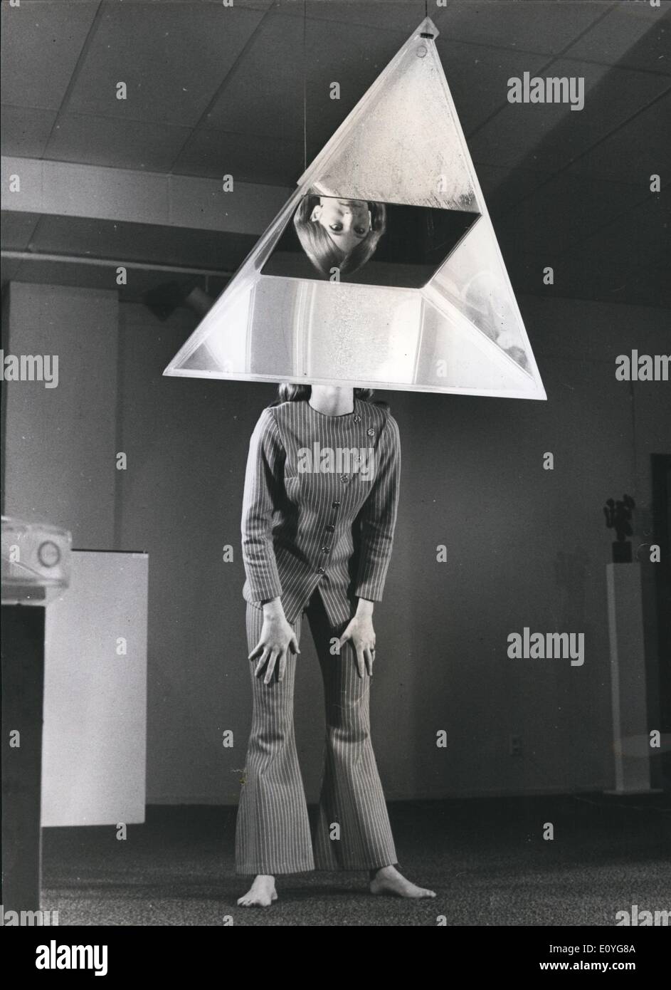 Jan. 1, 1970 - A tetrahedron hanging in the Dilexi Gallery is only half-filled with water. The result is that it produces an odd mirror-like effect when viewed from certain angles. Gallery visitor Robin Lyell's reversed image is reflected in this case from the underside of the water surface. Stock Photo