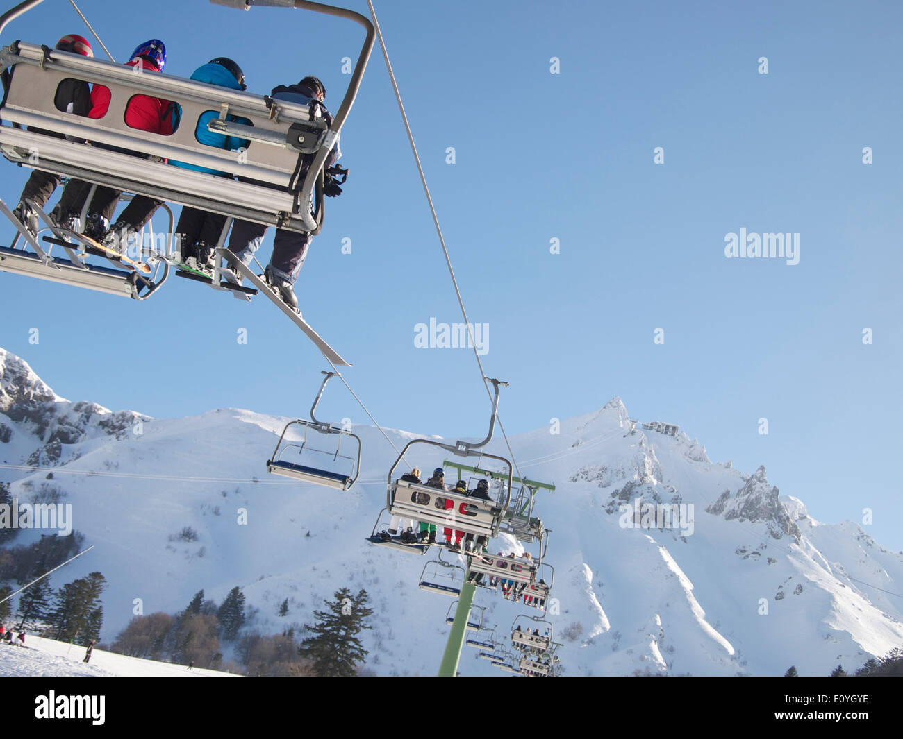 Skiers on a ski lift at Le Mont-Dore ski resort, Massif of Sancy, Auvergne, France Stock Photo