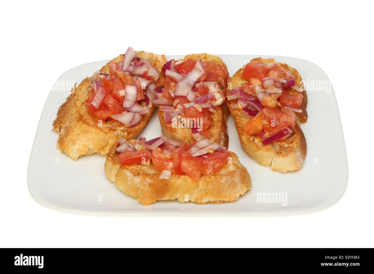 Tomato and red onion bruschetta on a plate isolated against white Stock Photo
