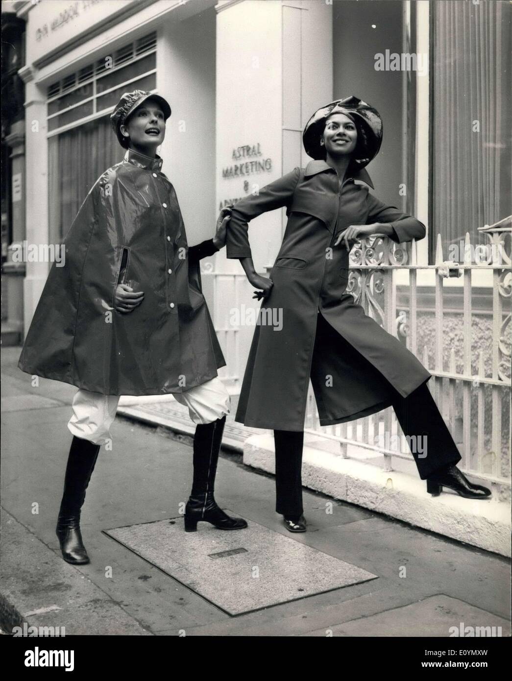 Oct. 27, 1970 - ALLIGATOR RAIN WEAR'S SPRING 1971 COLLECTION. ALLIGATOR today showed their Spring 1971 Rain wear Collection, which included a range of coats and capes by Pierre Cardin, the famous Paris designer. KEYSTONE PHOTO SHOWS: Model SHOSHANA wears ''Caper'', a P.V.C. single breasted cape from Alligator's Spring 1971 rain wear range., with contrast stitching around the standa way collar, stud tab and arm openings, worm with white P.V.C. knickerbackers-and on right, model SONIA wears ''Elysee''-one of Pierre Cardin's designs for Alligator Rain wear-a midi zip-up raincoat in Travira Rayen Stock Photo