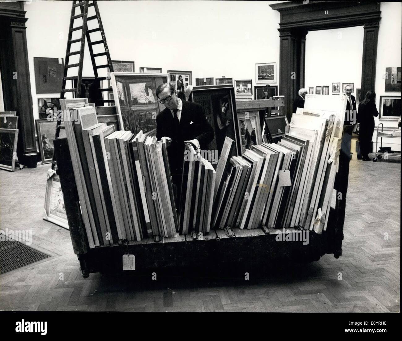 Apr. 04, 1971 - Preparing for the Royal Academy summer exhibition: Every year the Royal Academy faces the immense task of getting their Summer Exhibition ready by early May. Its Selection Committee, traditionally 15 Royal Academicians, has to consider some 12,000 paintings, drawings and pieces of sculpture. The next stage is left to the Hanging Committee which make the final choice. Photo shows Sir Thomas Monnington, President of the Royal Academy, looks at some of the paintings during today's preparation for the hanging. Stock Photo