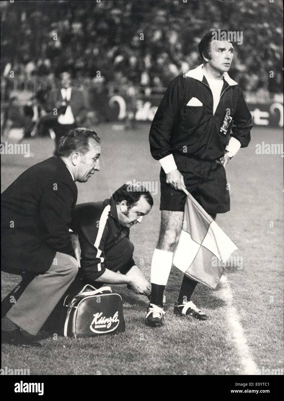 May 13, 1971 - When the Referee Changes with the Lines-man: A very rare thing happened during the last night's international football game between Switzerland and Greece in Berne: A sudden muscular strain obliged the welsh referee J.P.Jones to abandon his job and to change with his linesman T.H.C. Reynolds. Photo shows Referee Jones as linesman. The masseur of the swiss team, M.Haner, gives him a paincalming injection, while the famous swiss referee Gottlieb Dienst (referee in the world-cup final England-Germany in 1966) is watching this unusual operation at the sideline. Stock Photo
