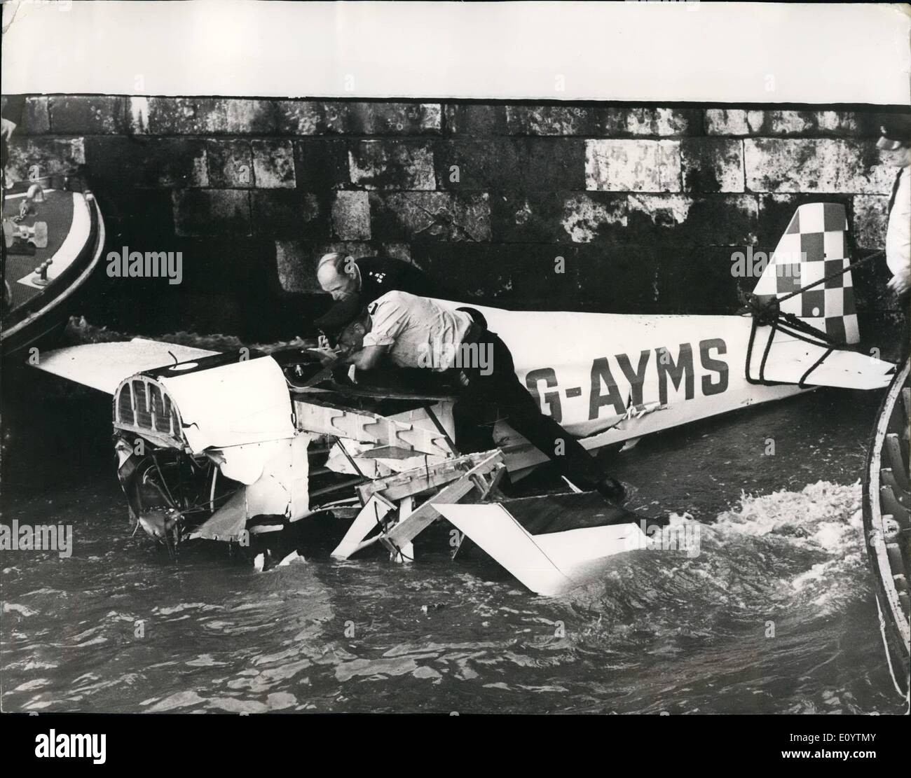 Jun. 06, 1971 - Pilot Dies In Crash As He Avoids Pier: A single-seater Owl Midget Racer crashed into the Thames yesterday, killing the pilot, and narrowly missing about 100 people on Greenwich Pier. The pilot pulled his light aircraft out of a dive which would have sent it crashing into the crowded pier. Within minutes of the crash, firemen had smashed into the plane's cockpit with axes. but the pilot, Mr. Peter Terence Gent Eggett, of Garden Wood Road, East Grinst-ad, Sussex Stock Photo