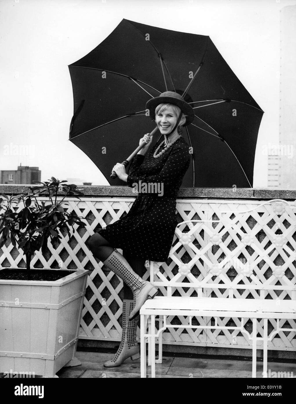 Actress Bibi Andersson in rain on balcony Stock Photo