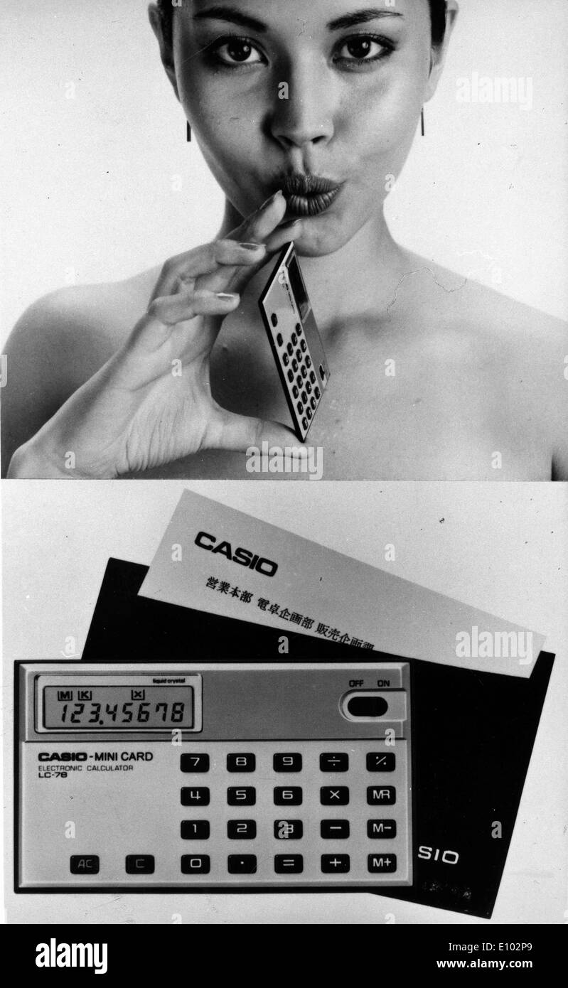 Model displays slim business card sized Casio calculator designed to fit in a pocket. Stock Photo