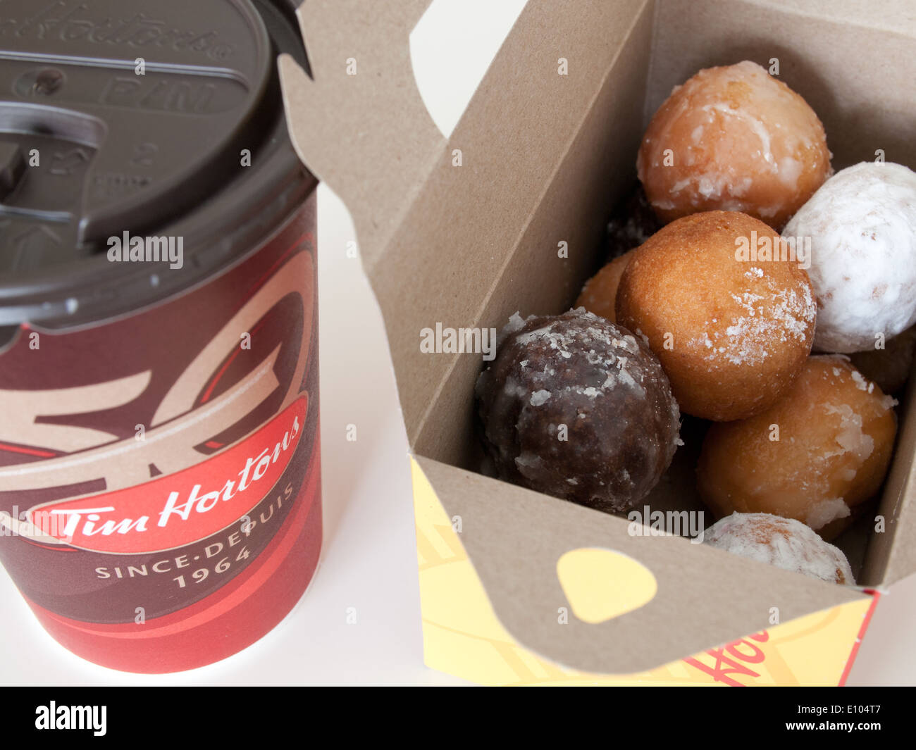 A Tim Hortons coffee cup and Timbits (doughnut holes, donut holes). Canada. Stock Photo