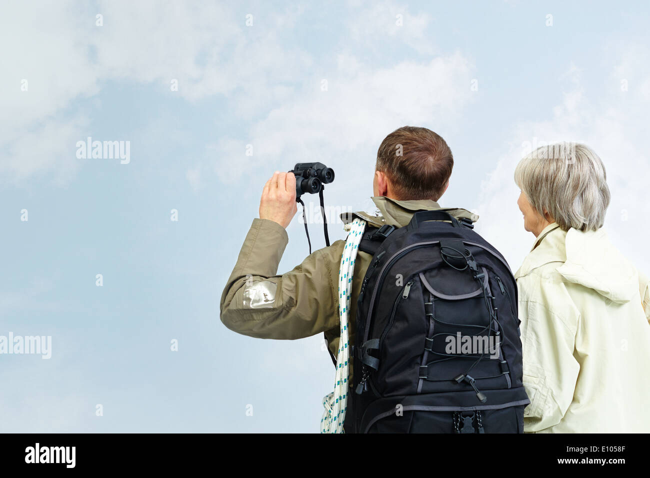 Backs of senior hikers with binoculars on trip Stock Photo