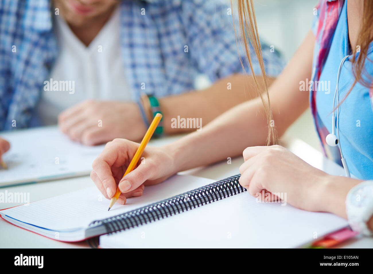 Hand of student with pencil carrying out written task or writing lecture Stock Photo