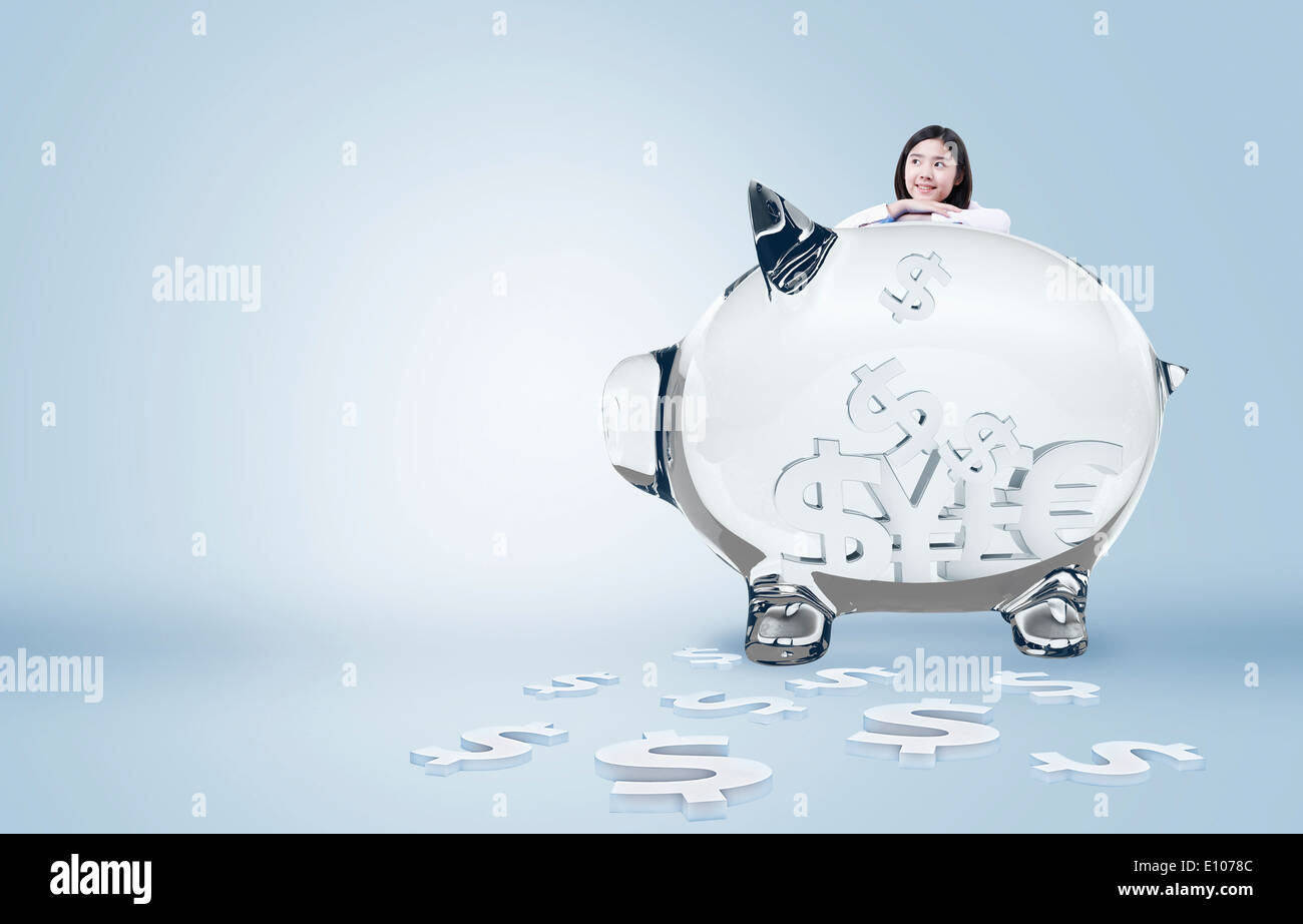 a girl standing behind a piggy bank Stock Photo - Alamy