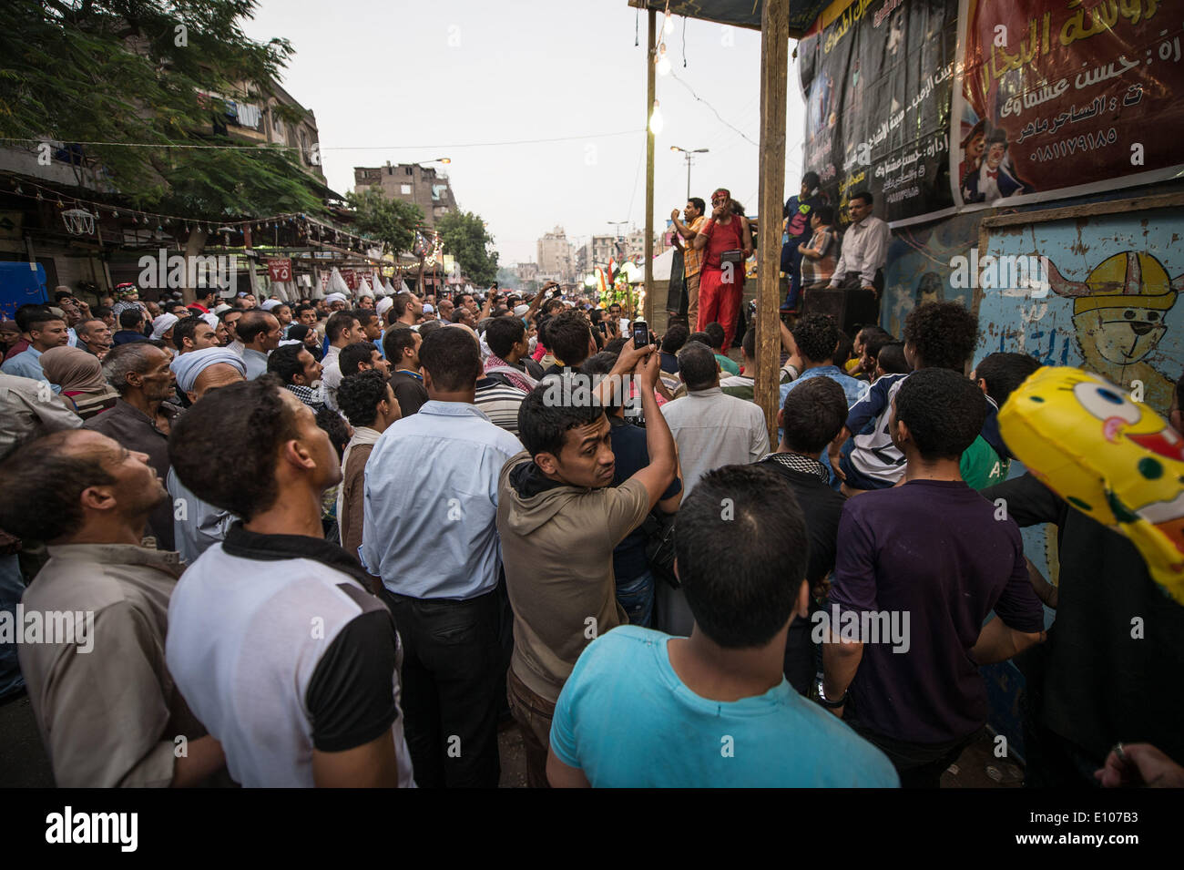 (140520) -- CAIRO, May 20, 2014 (Xinhua) -- Egyptians watch performance on the fair held near Sayeda Zeinab mosque for the celebration of 'Moulid Sayeda Zeinab' festival, or the birthday of the granddaughter of Prophet Mohamed, in old Cairo, Egypt, May 20, 2014. (Xinhua/Pan Chaoyue) Stock Photo
