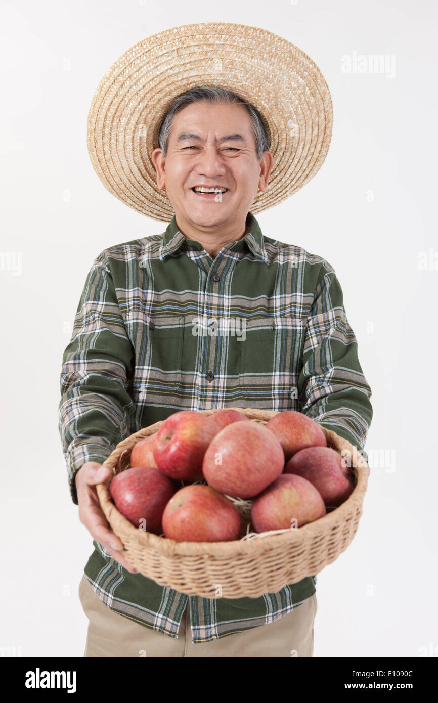 an old man holding a basket with apples Stock Photo Alamy