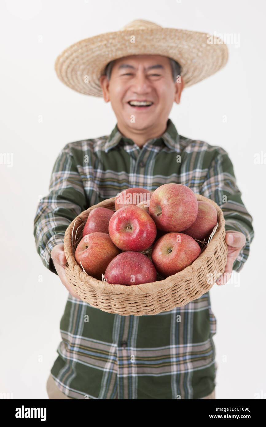 an old man holding a basket with apples Stock Photo - Alamy