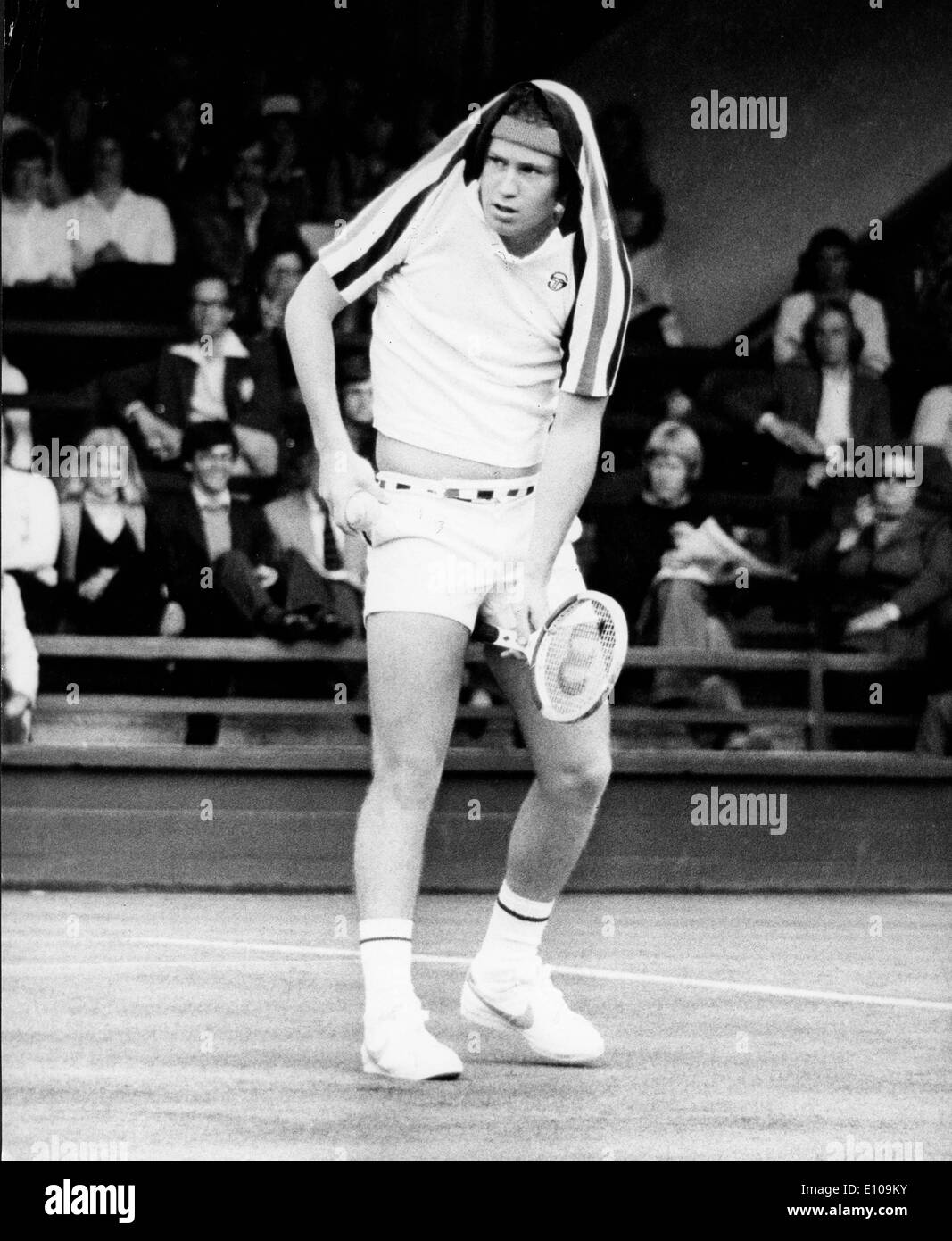 Tennis player John McEnroe covers head from rain Stock Photo
