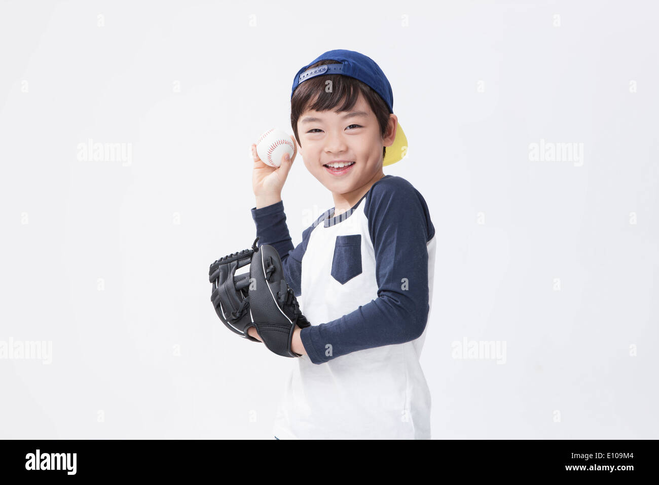 a young boy posing with a baseball mitt and a ball Stock Photo
