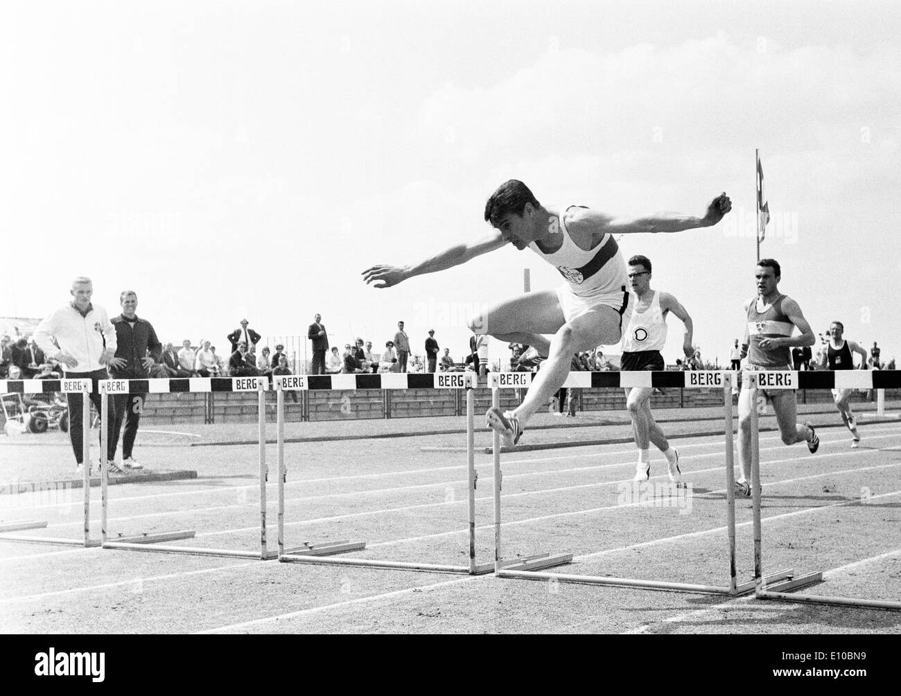 Sixties, black and white photo, sports, Athletics, sports meeting 1965 in Gelsenkirchen-Buer, track racing, hurdling, men, ahead Ferdinand Haas of of Bayer Leverkusen, D-Gelsenkirchen, D-Gelsenkirchen-Buer, Ruhr area, North Rhine-Westphalia Stock Photo