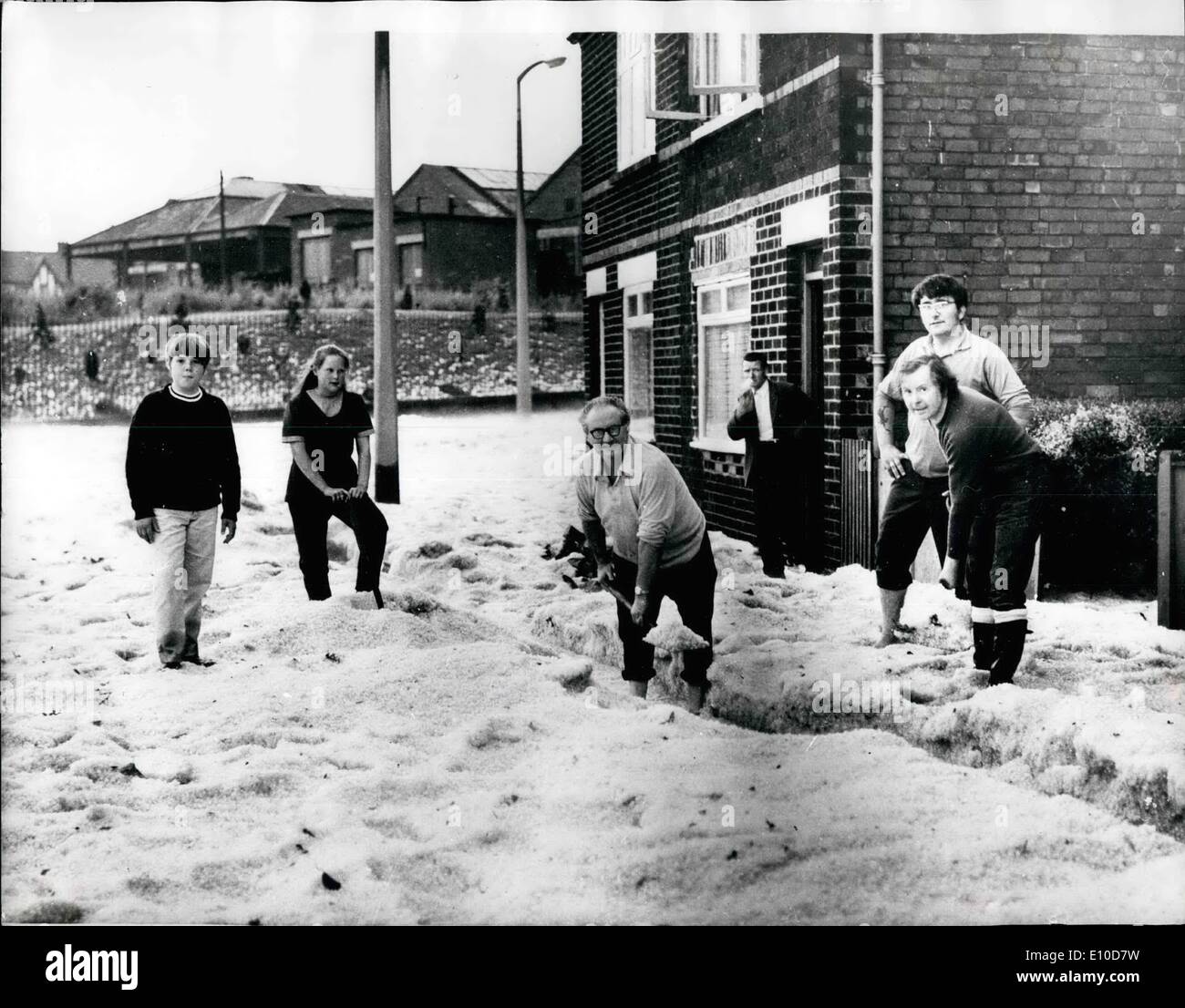 Jul. 07, 1972 - Hail the feet deep. Hailstones, the size of marbles, poured down in Nottingham, causing severe flooding. Boats had to be used to rescue people trapped in cars. Photo shows:- Residents clearing away the giant hailstones, which were as much as three feet deep, in Radford, Nottingham. Stock Photo