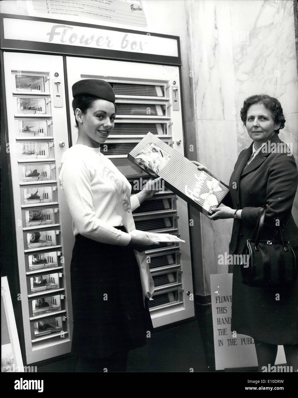 May 05, 1972 - Britain's First gift wrapped flower post . Britain's first flowers by post vending machines , dispensing pre packed , pre stamped boxes of rosed, went into operation today at the London Chief Office , King Edward Street, London, E.C.L as part of a Post Office trial. For two 50p coins , customers striped box. One 50p coin buys a smaller box containing one rose and a greetings card. Photo shows Miss Dorothx , director of London Postal region , purchases a box of nine roses from the vending machine (seen behind) after inserting two 50p coins today Stock Photo