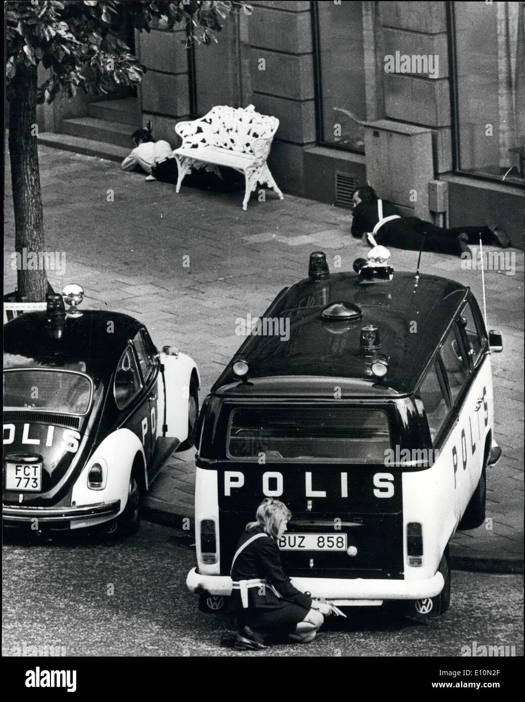 Aug. 08, 1973 - Gunman Holds Hostages In Stockholm Bank. A policewoman, gun in hand (foreground) crouches behind a police van, outside the bank in Stockholm where a gunman is holding four hostages. The gunman is holding the hostage captive in a vault in the bank. Stock Photo