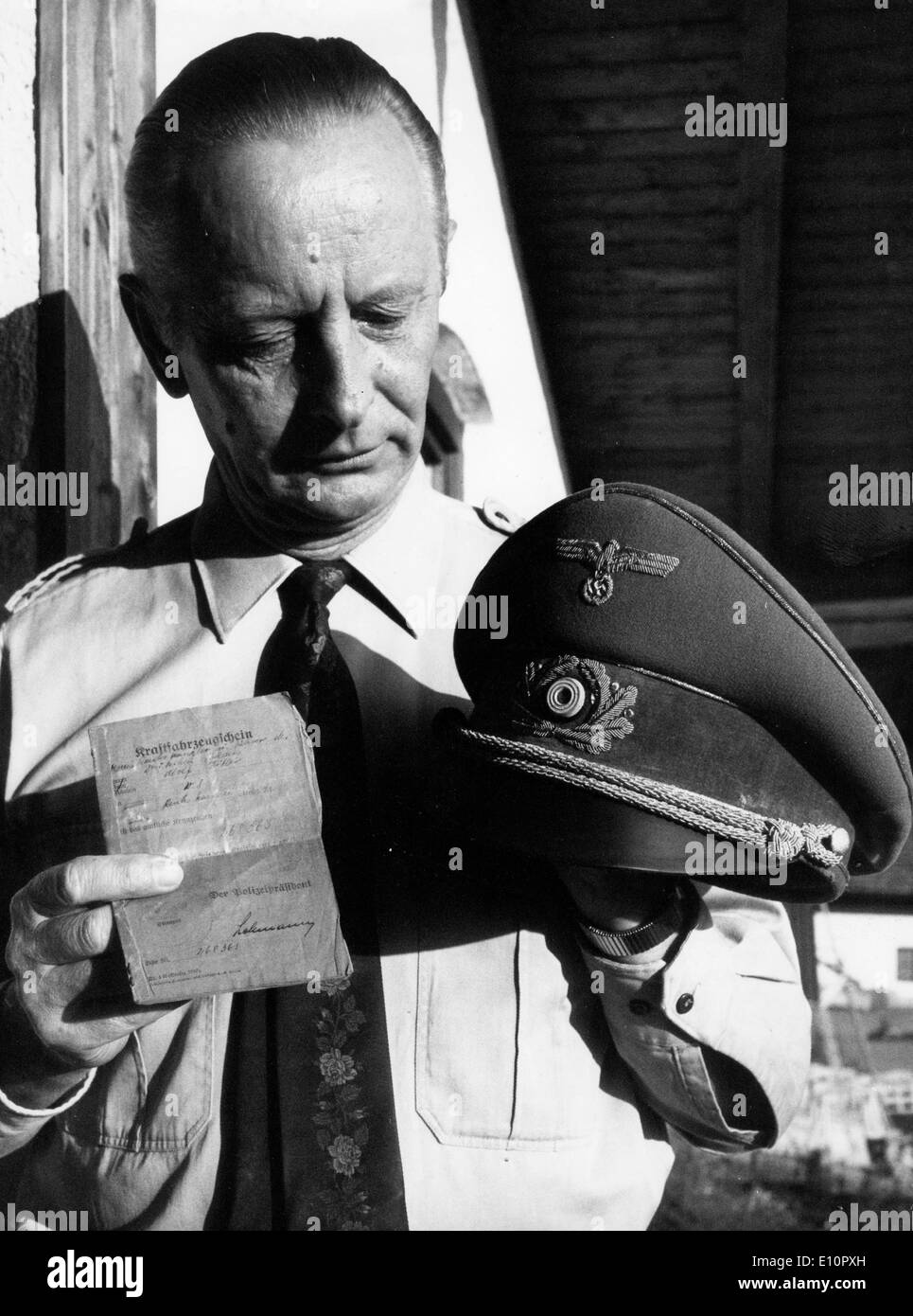 Auctioneer HERMANN-OTTO WINIARSKI showing the driver's license and uniform hat of Hitler Stock Photo