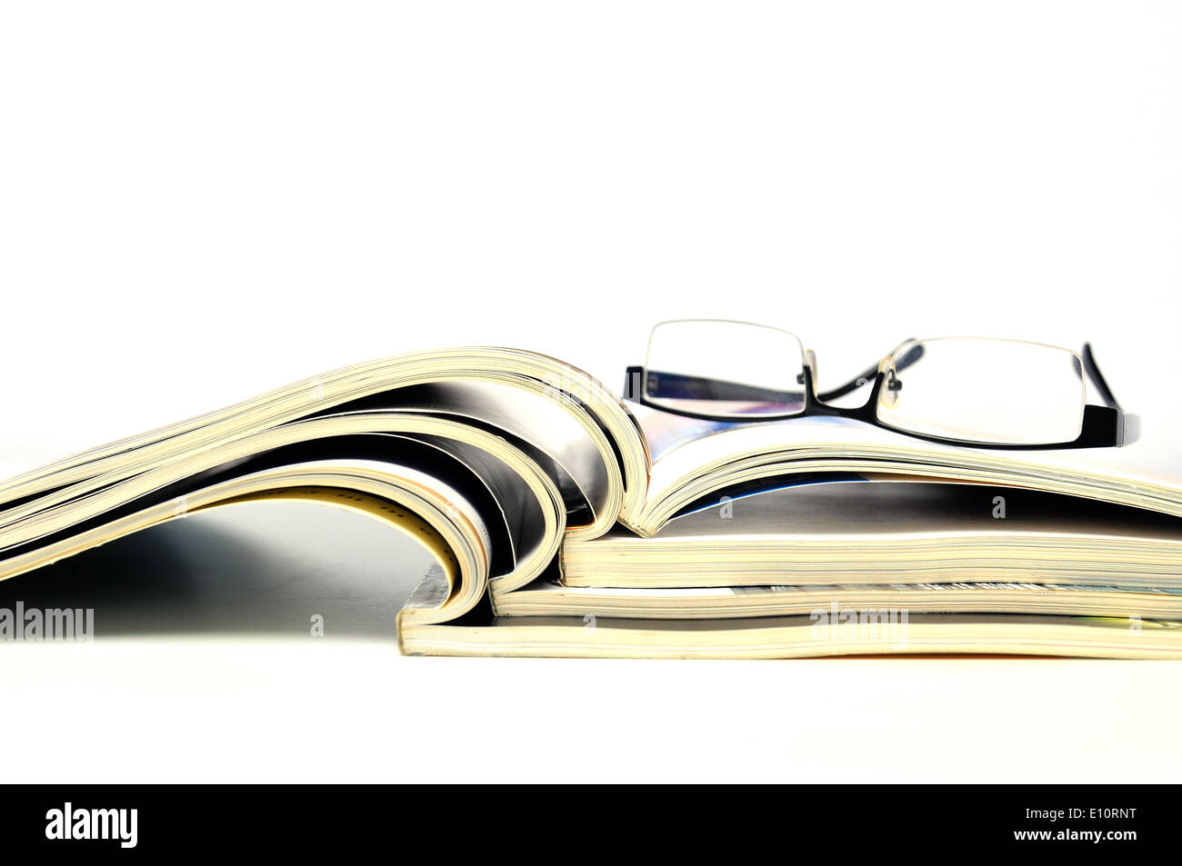 Open magazines with black glasses on white background Stock Photo