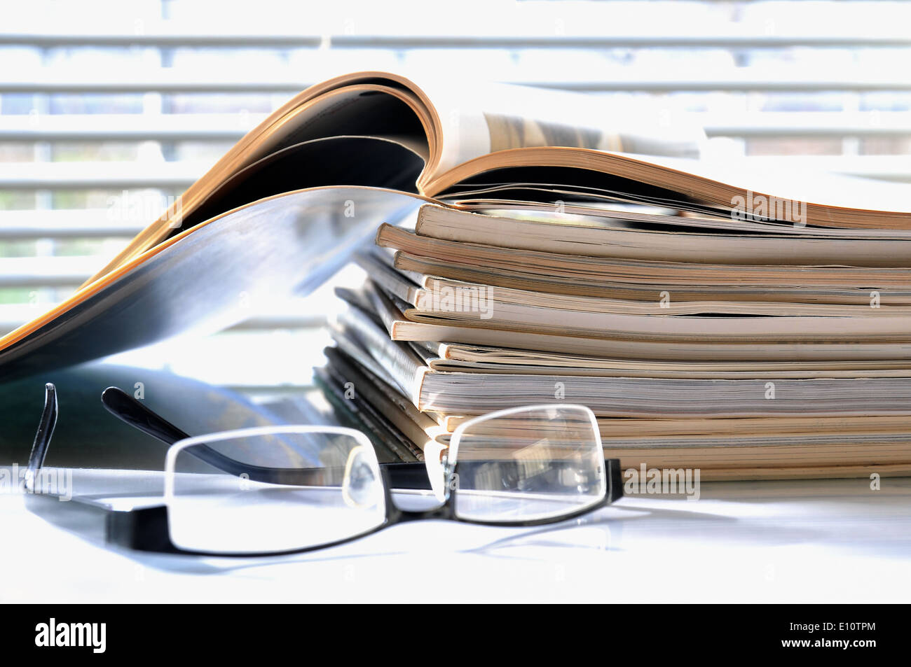 Stack of magazines with black glasses Stock Photo