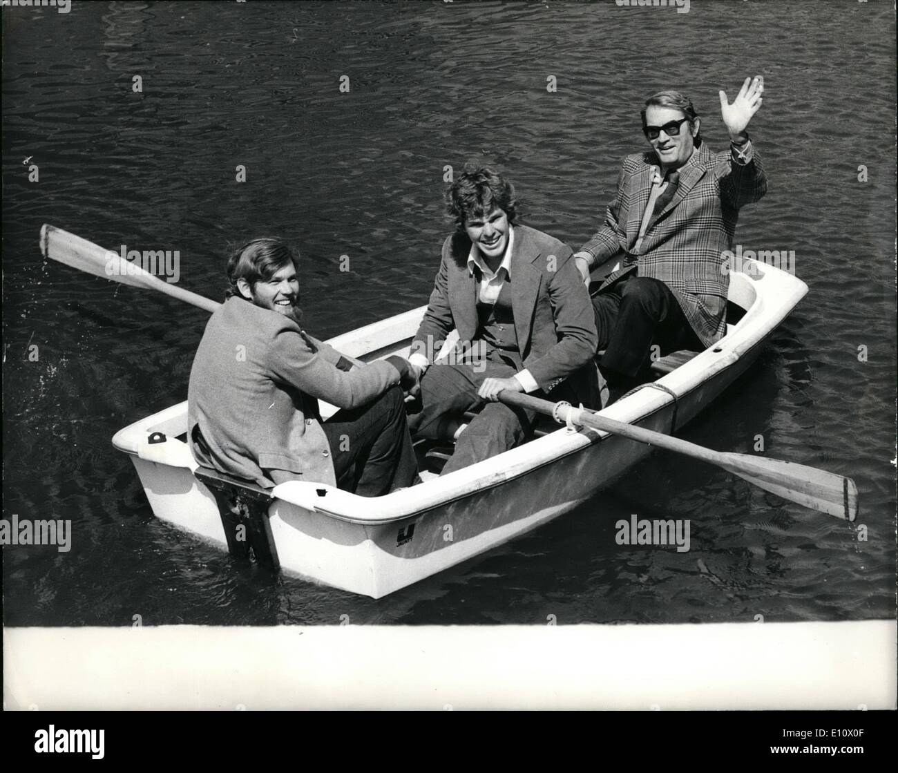 May 05, 1974 - Three men in a boat.: The new Gregory Peck film ''The Dove'' based on the true round-the-world voyage of Robin Lee Graham, will have a Royal World Premiere before Princess Anne and Captain Mark Phillips in London on Wednesday, 22nd May. Photo shows pictured in a boat in a yachting marina at Tower Bridge yesterday were Robin Lee Graham on whose round-the-world voyage the film is based; on left); Joseph Bottoms, who plays Robin's part in the film ''The Dove'', and Gregory Peck (right) Stock Photo