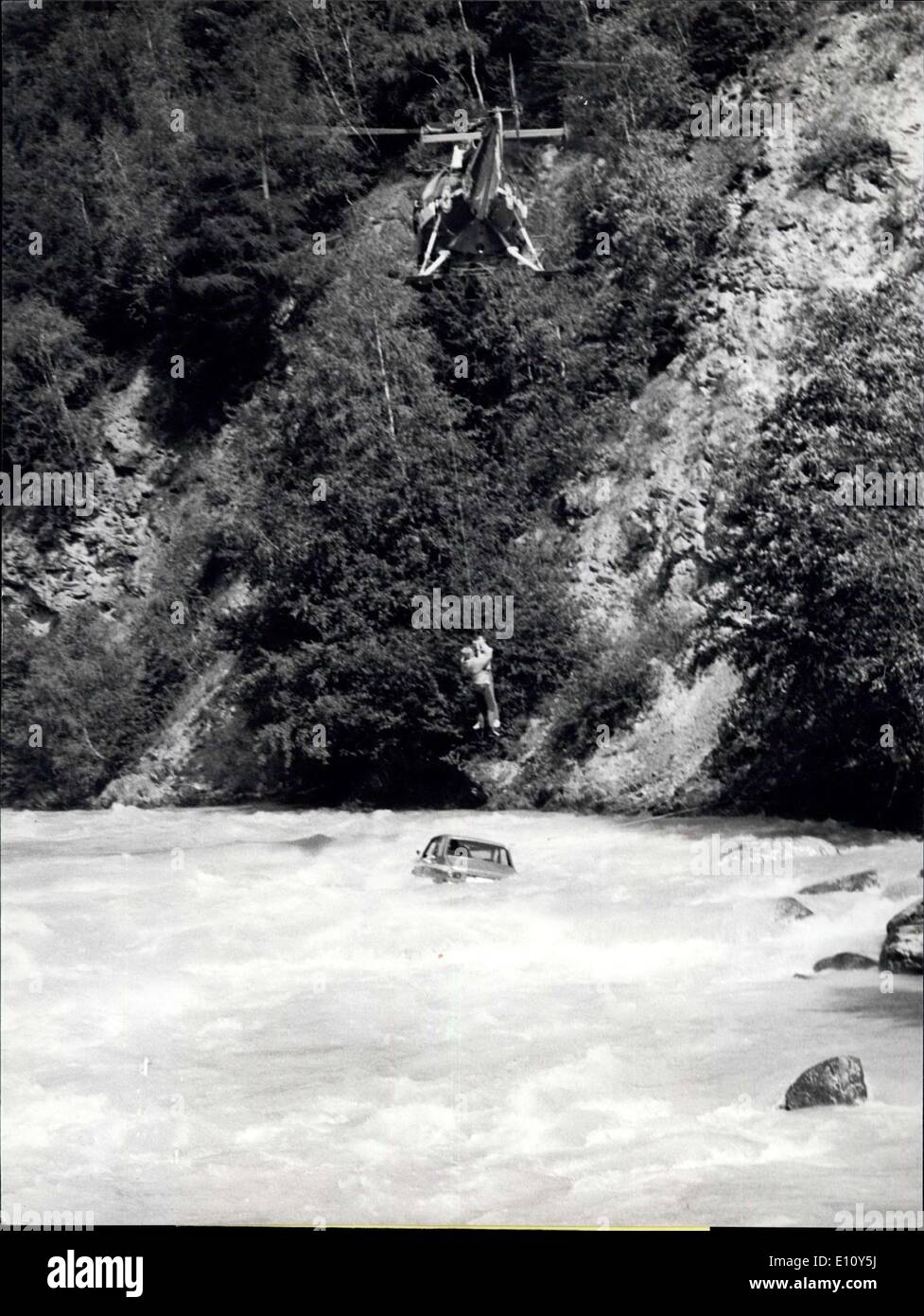 Aug. 12, 1974 - Spectacular Rescue Operation: A highly spectacular rescue operation took place in these days near Brug in the canton of Wallis in Switzerland. A car had an accident and felt in the torrent water of the Rhone. The helicopter of the ''Air Zermantt''and the Swiss Air Rescue arrived only 20 minutes after the accident on the place and liberated the passengers of the car from their dangerous and outmost uncomfortable situation. Photo shows the driver of the car looks out for the helicopter. The car had before made a fall of about 25 feet Stock Photo